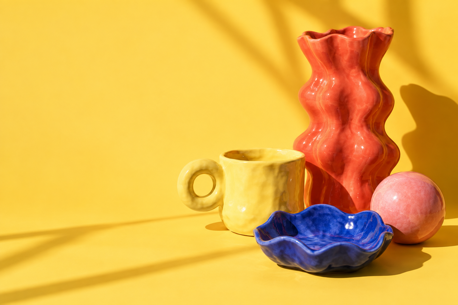 Piezas de cerámica de colores en un bodegón conceptual amarillo